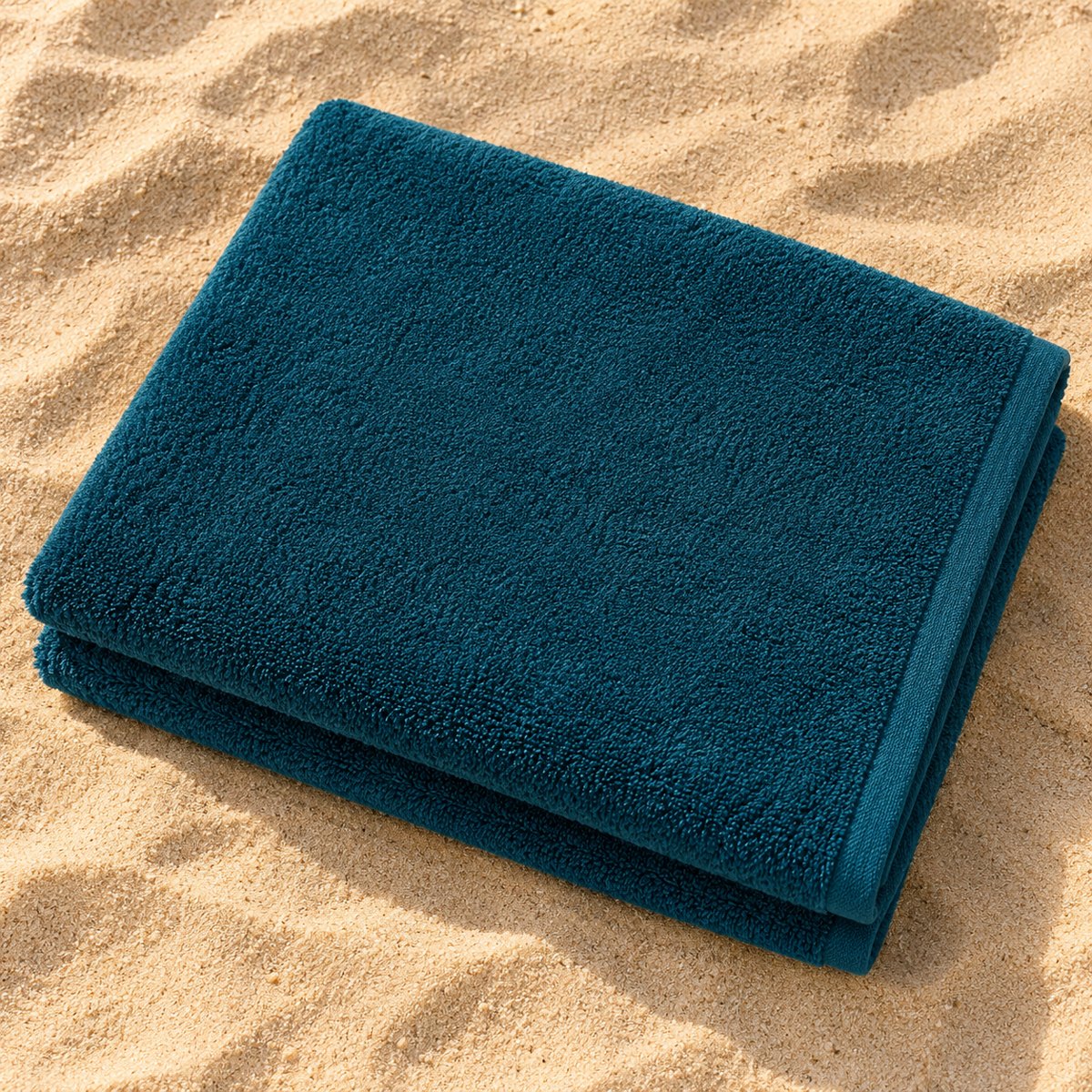 Petrolkleurige handdoek op het strand
